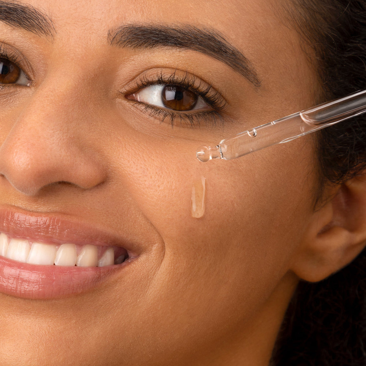 Woman applying Medik8 Hydr8 B5 hyaluronic acid serum with the dropper